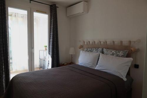 a bedroom with a large bed and a window at Lora Apartment with Garden & Pool in Mandelieu-La Napoule