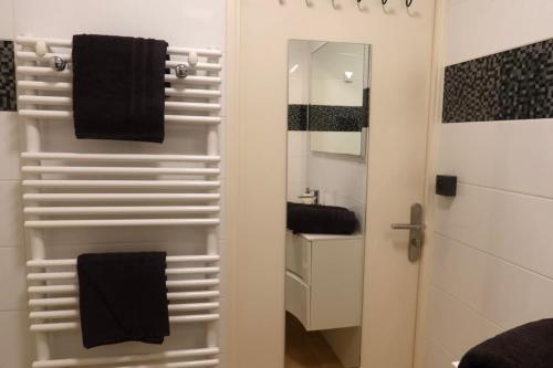 a bathroom with a towel rack and a mirror at Lora Apartment with Garden & Pool in Mandelieu-La Napoule