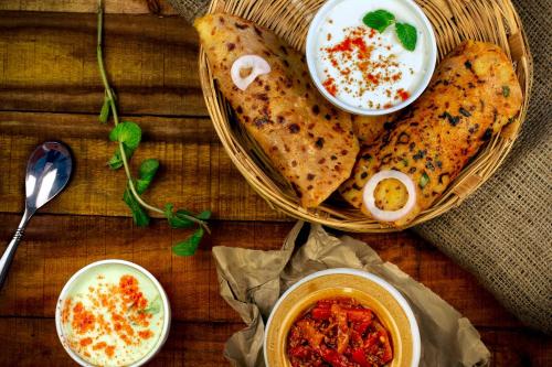 a table with a basket of food and bowls of soup at Townhouse Miramar View Point in Goa