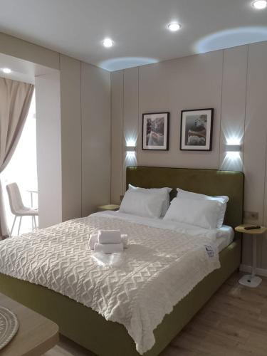 a bedroom with a large bed with two towels on it at WOODSPACE Apartment in Shchūchīnsk