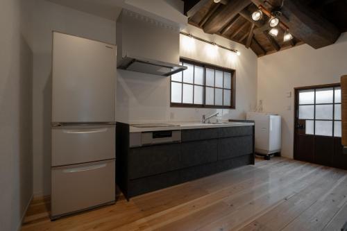 a kitchen with a refrigerator and a sink in it at AWAJI PRIVATE Villa 神蔵-KAGURA in Awaji