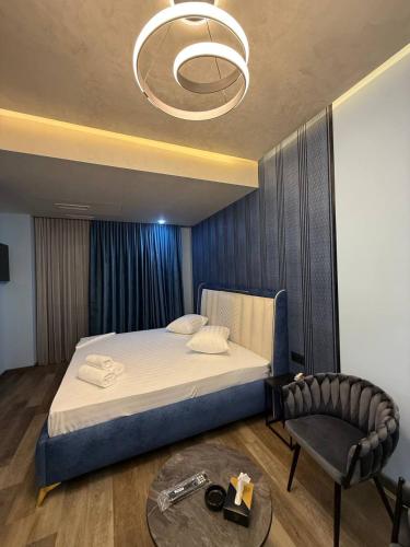 a bedroom with a bed and a chair and a table at Fidji Hotel in Yerevan