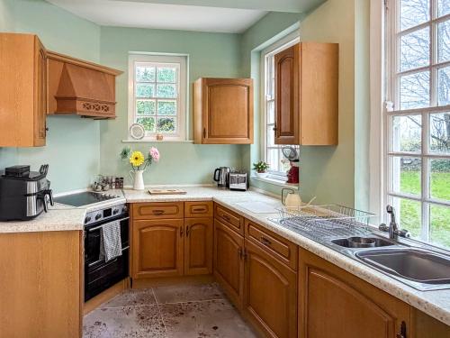 a kitchen with wooden cabinets and a sink at Hilston Park in Monmouth