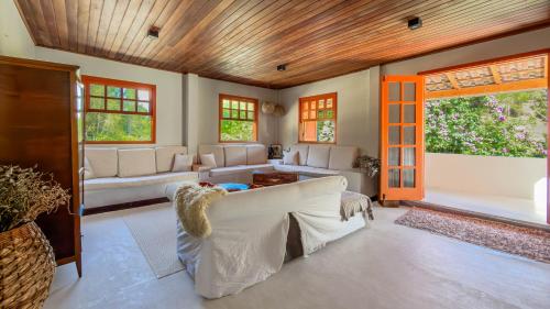 a living room with a white couch and windows at Sítio D Ouro in Marechal Floriano