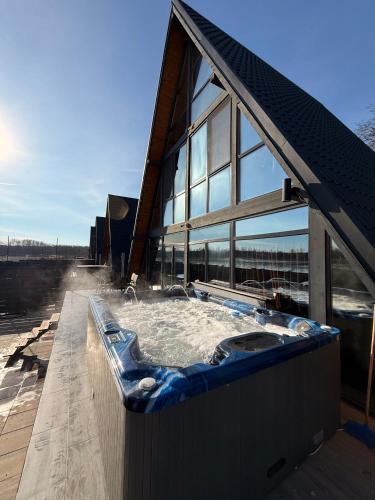 a hot tub on the side of a building at Cabane Masaya Aframe in Periş