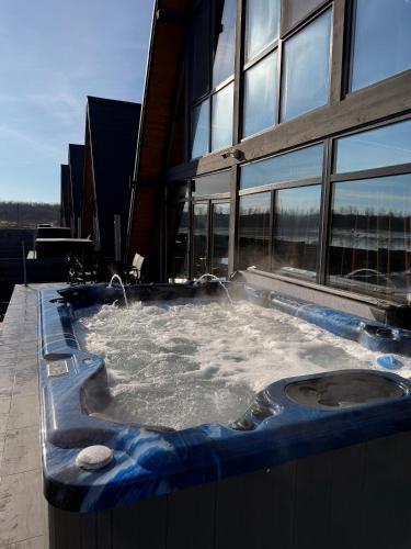 a jacuzzi tub on the side of a building at Cabane Masaya Aframe in Periş