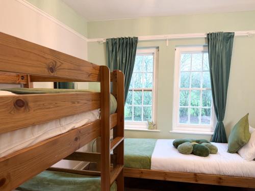 a bedroom with two bunk beds and two windows at Hilston Park in Monmouth