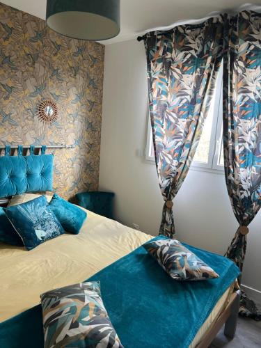 a bedroom with a bed with blue sheets and a window at Guedon sandrine in Grosley-sur-Risle