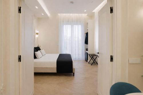 a bedroom with a bed and a large window at SOFIA Suites & Rooms in Pompei