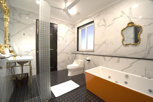 a bathroom with a tub and a toilet and a sink at Mayfair Oasis Resort & Convention in Jhārsuguda