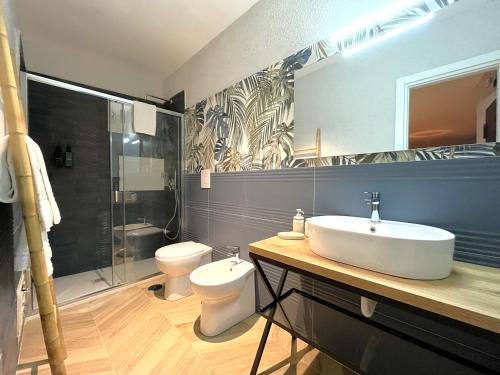 a bathroom with a sink and a toilet and a shower at Aura Suites Napoli in Naples