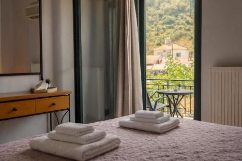 a bedroom with three towels on a bed with a balcony at villa Fotini 2 (new) in Syvota