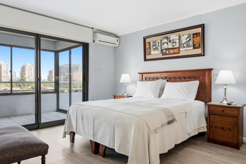 a bedroom with a bed and a large window at Isabel Suites Vitacura in Santiago
