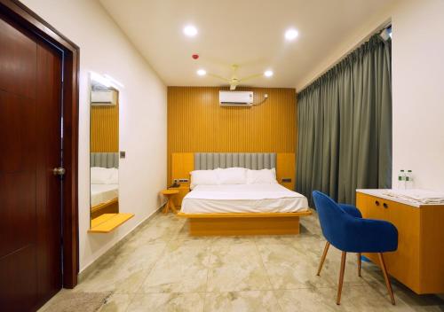 a hotel room with a bed and a blue chair at Avenue A boutique hotel in Vijayawāda