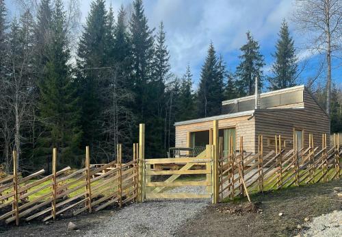 a wooden fence in front of a small cabin at Architect-Designed Cabin By Lake With Sauna in Homle
