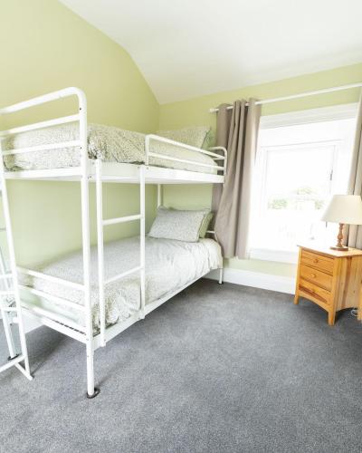 a bedroom with two bunk beds and a window at Making Tracks Hostel in Portlaoise