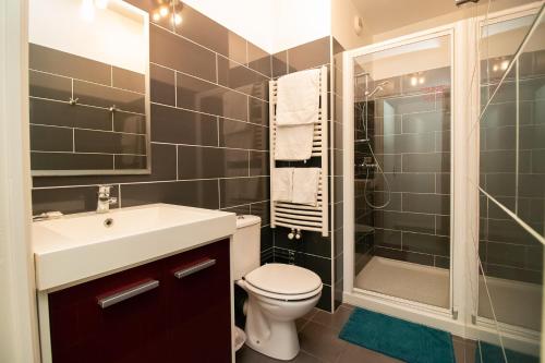 a bathroom with a sink and a toilet and a shower at Hotel Le Richelieu in Le Tréport