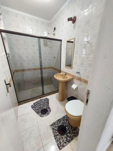 a bathroom with a shower and a toilet and a sink at Pousada recanto das ondas in Macaé
