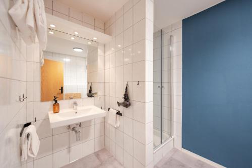 a bathroom with a sink and a shower at Weitnau Stays - Hotel & Hostel in Weitnau