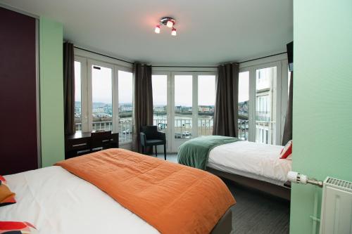 a hotel room with two beds and a window at Hotel Le Richelieu in Le Tréport