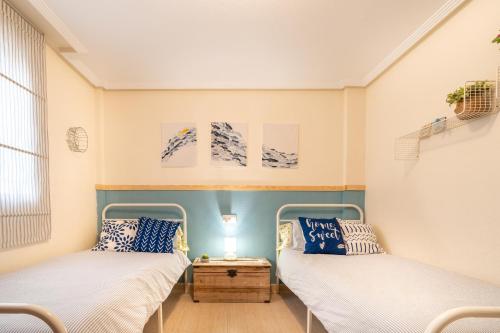 two beds in a room with blue and white at Chalet adosado en la playa de Torre de la Horadada in Torre de la Horadada