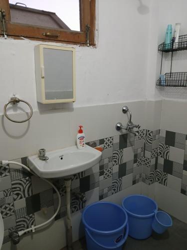a bathroom with a sink and a mirror and a tub at Gharonda in Dehradun