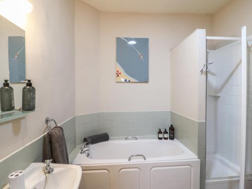 a white bathroom with a tub and a sink at Little Launde Cottage in Leicester