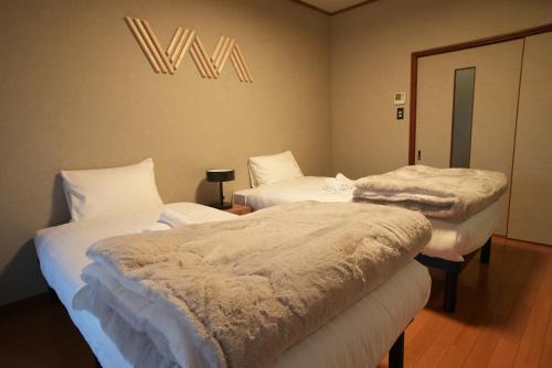 a room with three beds with white comforters at 侘然 - Wabizen - in Ikeda