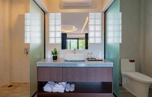 a bathroom with a sink and a toilet at The Sears Residence Siem Reap in Phumĭ Réach Born (2)