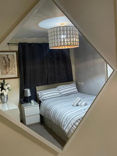a bedroom with a bed and a chandelier at Casa Centro two bedroom apartment in Wolverhampton