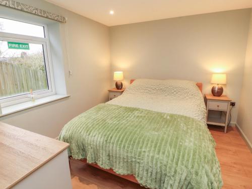 a bedroom with a bed and a window at The Nook in Wigton