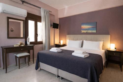 a bedroom with a large bed with towels on it at Villa Fotini in Syvota