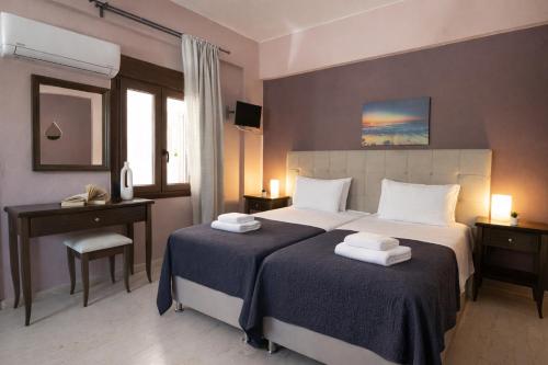 a hotel room with two beds with towels on them at Villa Fotini in Syvota
