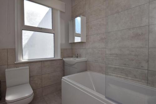 a bathroom with a tub and a toilet and a sink at 4 Bed in St. Austell oc-t32965 in St Austell
