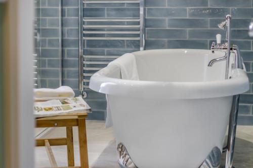 a white bath tub in a bathroom with blue tiles at 5 Bed in Llangollen oc-l34205 in Llangollen
