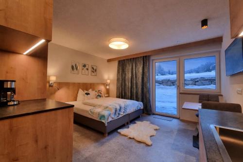 a bedroom with a bed and a large window at St. Florian Appartements in Galtür
