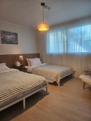 a hotel room with two beds and a window at STAY Humming in Seoul