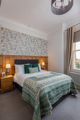 a bedroom with a large bed with a green blanket at The Black Swan Inn in Pickering