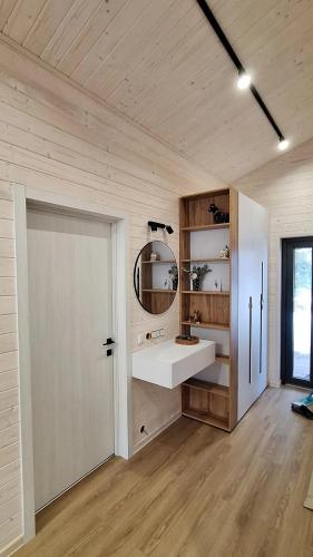 a bathroom with a sink and a mirror and a door at Садиба Пташка in Krivopolʼye