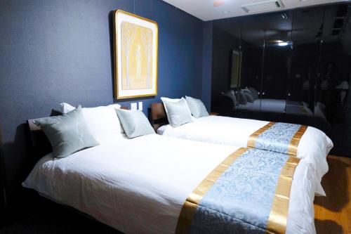 two beds in a room with blue walls at ゲストハウス 清水銀座 in Shizuoka