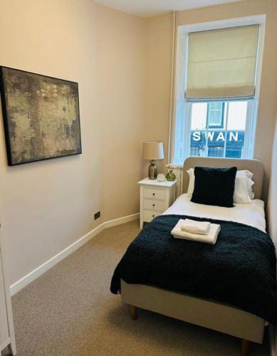 a bedroom with a bed and a window at HORSEMARKET on the square in Kelso