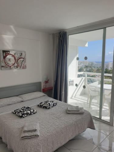 a bedroom with a bed and a view of a balcony at Ponderosa Holiday Studio 701 in Playa de las Americas
