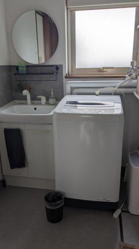 a small bathroom with a sink and a refrigerator at Aioi house in Tsubetsu