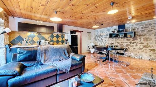 a living room with a leather couch and a table at La Ferrandaise in Chambon-sur-Lac