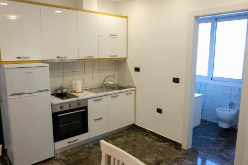 a kitchen with white cabinets and a sink at Era Palace Apartments in Vlorë
