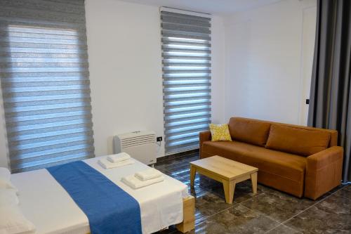 a bedroom with a bed and a couch at Era Palace Apartments in Vlorë