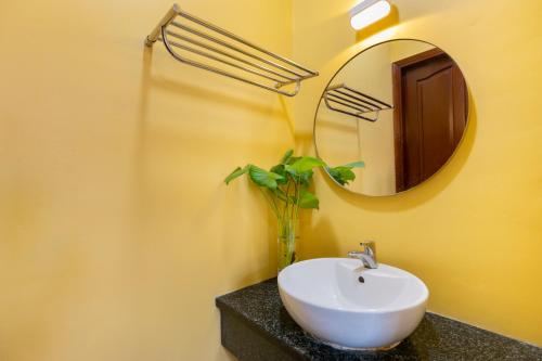 a bathroom with a white sink and a mirror at Villa 25 Lạc Long Quân in Vung Tau