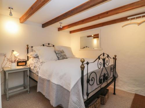 a bedroom with a bed and a table and a mirror at The Old Studio in Penzance