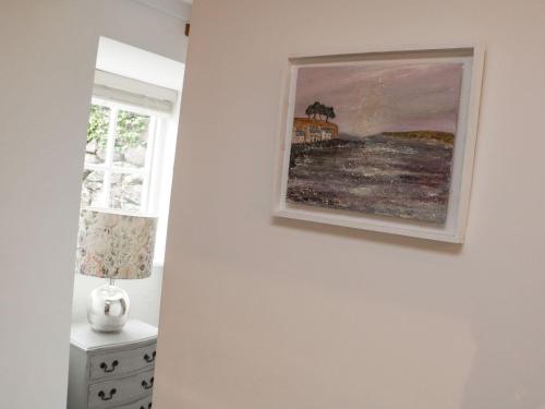 a painting hanging on a wall next to a window at The Old Studio in Penzance