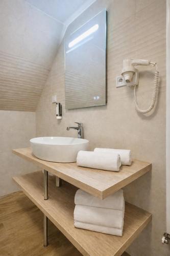 a bathroom with a sink and a mirror and towels at Apartmány Ella in Hřensko
